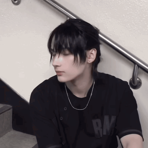 A Young Man Wearing A Black Shirt With Rm On The Back GIF