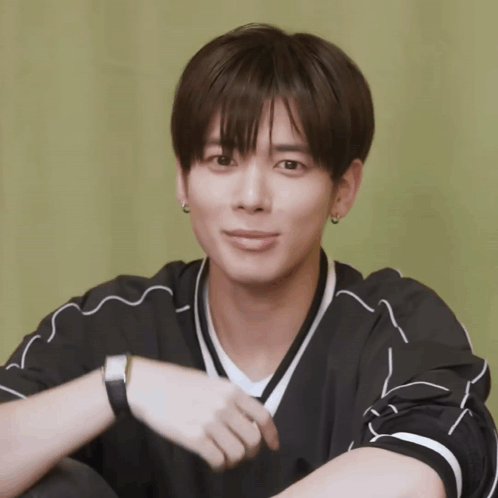 A Young Man Wearing A Black Shirt With White Stripes And A Watch On His Wrist GIF