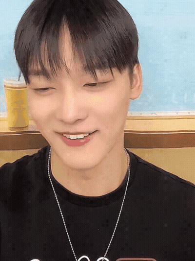 A Young Man Wearing A Black T-Shirt And A Necklace With The Letter S On It GIF