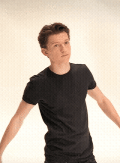A Young Man Wearing A Black T-Shirt Is Standing With His Arms Outstretched . GIF