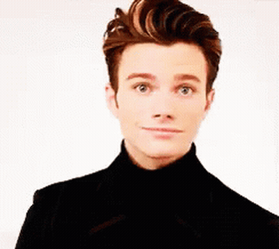 A Young Man Wearing A Black Turtleneck And A Black Jacket Is Making A Funny Face . GIF