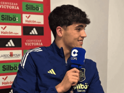 A Young Man Wearing A Blue Adidas Jacket Is Talking Into A Cope Microphone GIF