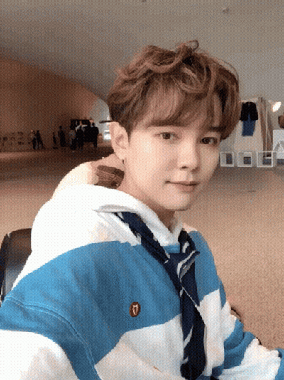 A Young Man Wearing A Blue And White Striped Shirt With A Heart Embroidered On It GIF