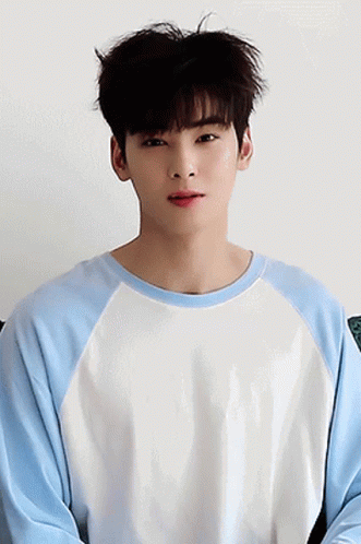 A Young Man Wearing A Blue And White Sweater Looks At The Camera GIF