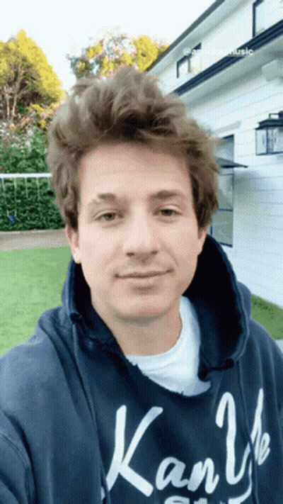 A Young Man Wearing A Blue Kanji Hoodie Takes A Selfie GIF