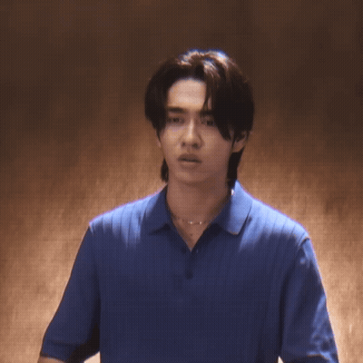 A Young Man Wearing A Blue Shirt And A Necklace Is Looking At The Camera GIF