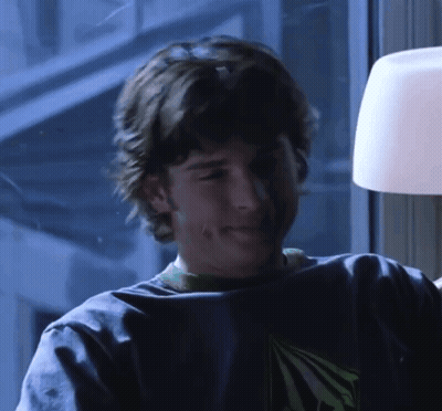 A Young Man Wearing A Blue Shirt With A Green Triangle On It GIF