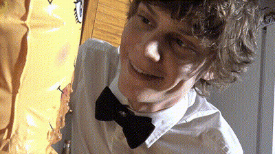 A Young Man Wearing A Bow Tie Is Smiling GIF
