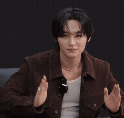 A Young Man Wearing A Brown Jacket And A Necklace Is Clapping GIF