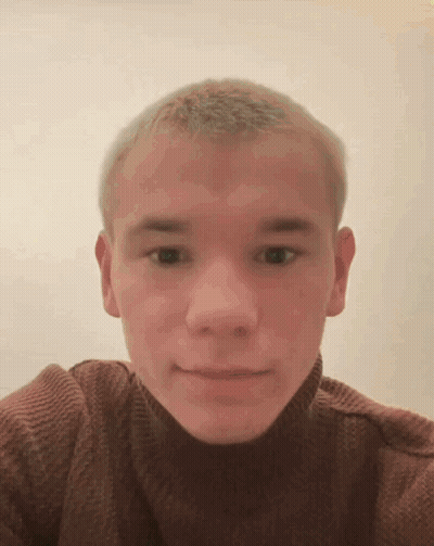 A Young Man Wearing A Brown Turtleneck Sweater Is Taking A Selfie GIF