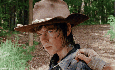 A Young Man Wearing A Cowboy Hat Is Being Held By Another Person 'S Hand GIF