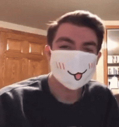 A Young Man Wearing A Face Mask With A Smiling Face On It GIF