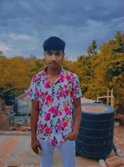 A Young Man Wearing A Floral Shirt Is Standing On A Roof GIF