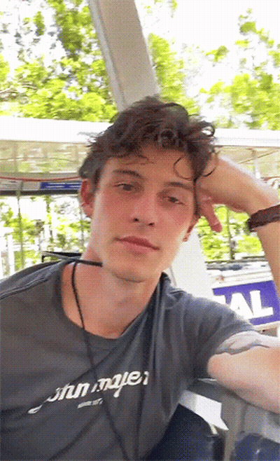 A Young Man Wearing A Gray Shirt That Says John Mayer On It GIF