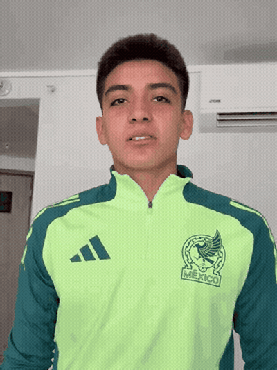 A Young Man Wearing A Green Adidas Jacket With Mexico On The Front GIF