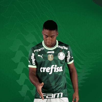 A Young Man Wearing A Green Crefisa Jersey Holds Out His Hand GIF