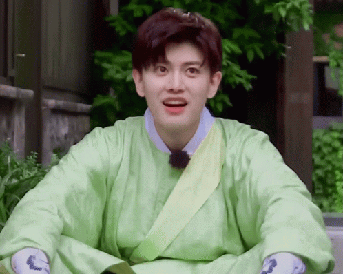 A Young Man Wearing A Green Robe With A Yellow Sash Around His Waist GIF