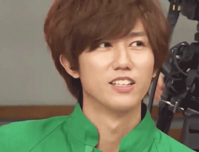 A Young Man Wearing A Green Shirt Is Smiling For The Camera GIF