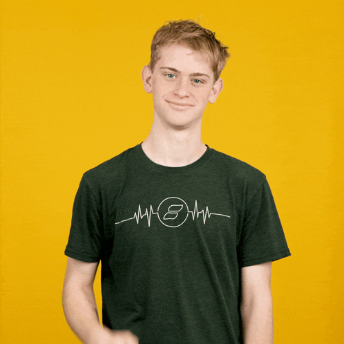A Young Man Wearing A Green Shirt With A Heartbeat And The Letter S On It GIF