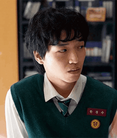 A Young Man Wearing A Green Vest And Tie Has A Name Tag With Chinese Characters GIF