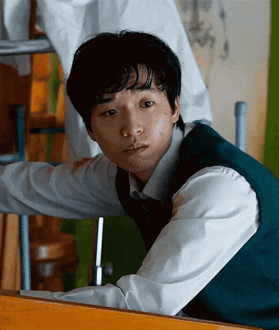 A Young Man Wearing A Green Vest And White Shirt GIF