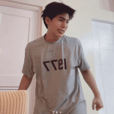 A Young Man Wearing A Grey T-Shirt That Says " Free " On It GIF