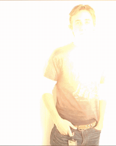 A Young Man Wearing A Harley Davidson T-Shirt Stands With His Hands In His Pockets GIF
