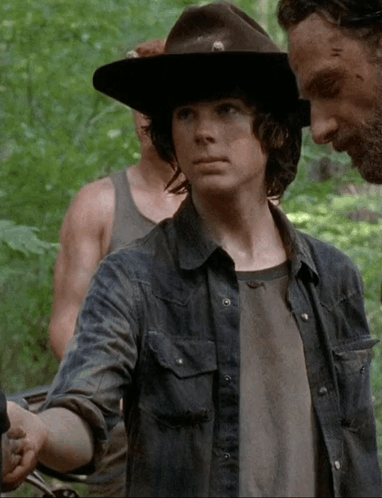 A Young Man Wearing A Hat And A Denim Shirt Is Standing Next To A Man With A Beard GIF