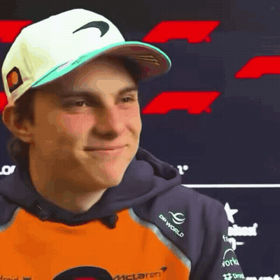 A Young Man Wearing A Hat And A Hoodie With The Word Mclaren On It . GIF