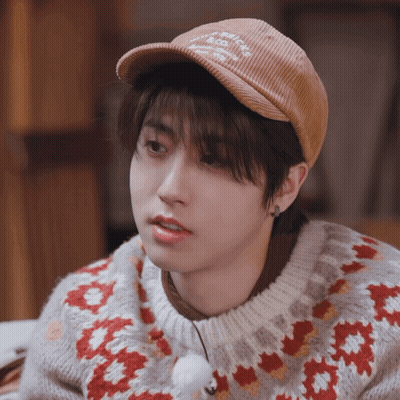 A Young Man Wearing A Hat And A Sweater With A Floral Pattern GIF