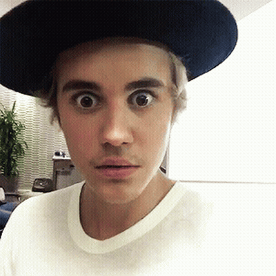 A Young Man Wearing A Hat And A White Shirt Looks Surprised GIF