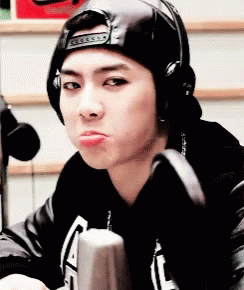 A Young Man Wearing A Hat And Headphones Is Making A Funny Face . GIF