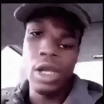 A Young Man Wearing A Hat Is Looking At The Camera . GIF