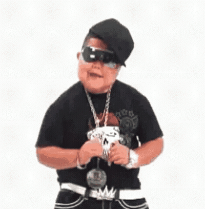 A Young Man Wearing A Hat , Sunglasses And A Chain Around His Neck Is Standing In Front Of A White Background . GIF