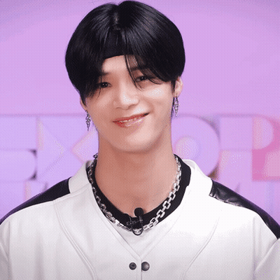 A Young Man Wearing A Headband And A Necklace Smiles GIF