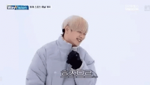 A Young Man Wearing A Jacket And Gloves Is Smiling . GIF