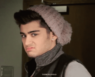 A Young Man Wearing A Knitted Hat And Earring Looks At The Camera With The Words Thisboyloves.id Below Him GIF