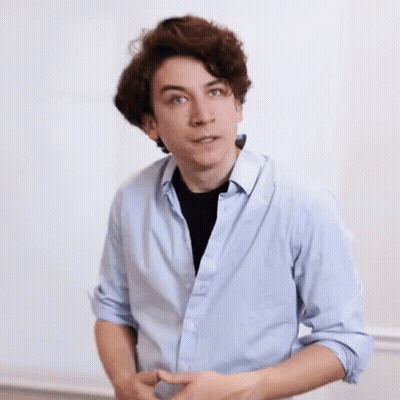 A Young Man Wearing A Light Blue Shirt And A Black Shirt GIF