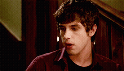 A Young Man Wearing A Maroon Shirt And A Black Shirt Is Making A Funny Face GIF