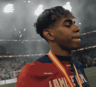 A Young Man Wearing A Medal Around His Neck With The Name Ibrahim On The Bottom GIF