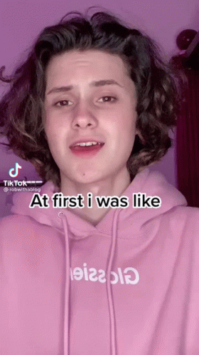 A Young Man Wearing A Pink Hoodie With The Words At First I Was Like Written On It GIF