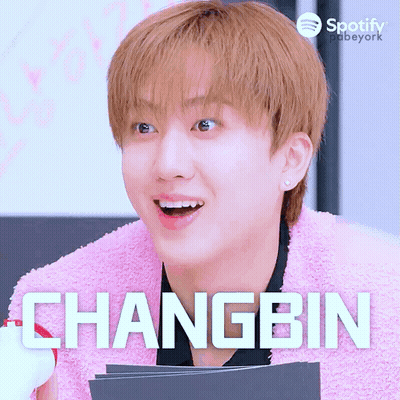 A Young Man Wearing A Pink Sweater And The Name Changbin GIF