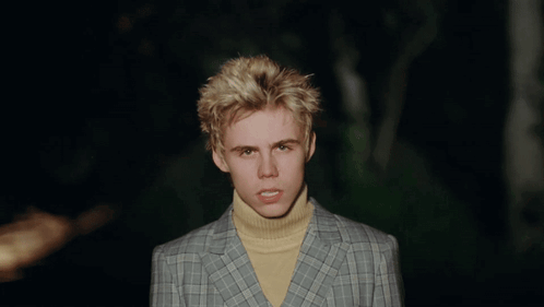 A Young Man Wearing A Plaid Jacket And Yellow Turtleneck GIF