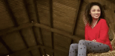 A Young Man Wearing A Plaid Shirt And A Black Shirt Is Standing In A Park . GIF