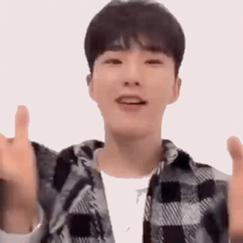 A Young Man Wearing A Plaid Shirt Is Giving A Thumbs Up Sign . GIF