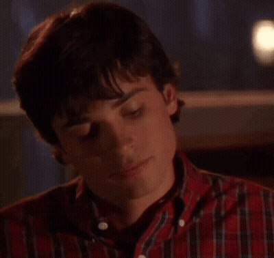 A Young Man Wearing A Plaid Shirt Is Looking At The Camera . GIF