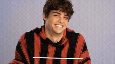 A Young Man Wearing A Red And Black Striped Shirt Smiles GIF