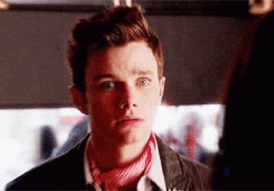 A Young Man Wearing A Red And White Scarf Looks At The Camera GIF