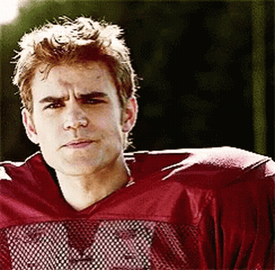 A Young Man Wearing A Red Football Jersey With The Letter M On The Front GIF