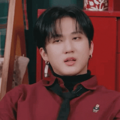 A Young Man Wearing A Red Shirt And A Black Tie Is Making A Funny Face . GIF